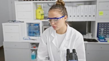 Gülümseyen genç kadın bilim adamı, laboratuvarda çalışan güzel bir İspanyol kadın, gözlük takıyor, tıbbi araştırmayı neşeyle kucaklıyor.