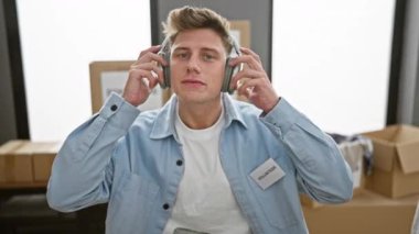 Kendine güveni tam beyaz bir adam hayır kurumunda gönüllü olarak çalışıyor, kulaklıklarını çıkarırken gülümsüyor.