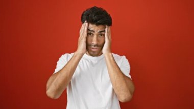 Kırmızı duvara karşı poz veren, beyaz gömlekli, yakışıklı, İspanyol bir adam..