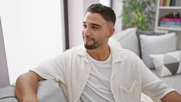 Hombre Árabe Joven Sentado Sofá Con Una Sonrisa Alegre Fresca — Vídeos de Stock