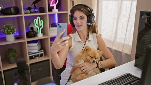 微笑み 自信を持って若いヒスパニック系女性は 彼女の犬とストリーマー 蒸気のビデオ通話をしている間 彼女のゲームルームでチリン — ストック動画