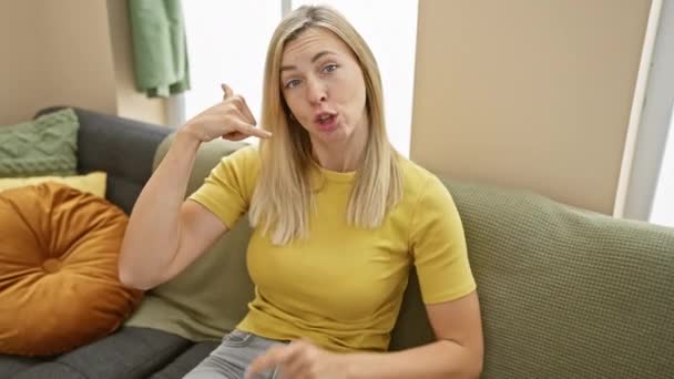 Jovem Mulher Loira Alegre Shirt Confiantemente Faz Gesto Chamada Telefone — Vídeo de Stock
