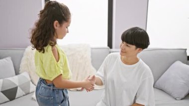 Evde, mutlu bir anne ve kız kanepede oturup birbirlerinin ellerini öperek birbirlerine kenetlenmiş aile ilişkilerinin sevincine güvenirler..