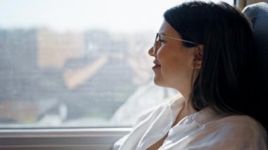 Genç, güzel İspanyol kadın gülümsüyor tren istasyonunda mutlu bir şekilde oturuyor.