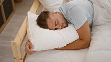 Genç bir adam minimalist bir yatak odasında huzur içinde uyur. Rahatlık ve rahatlık simgeler..