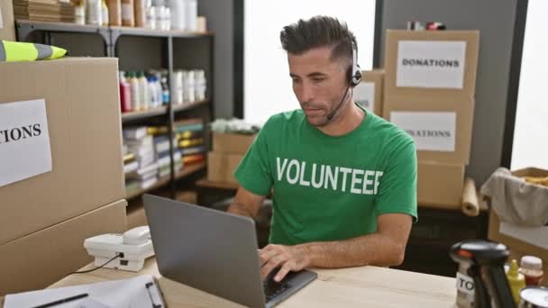 Joven Hispano Voluntario Usando Laptop Auriculares Sonriendo Centro Caridad — Vídeo de stock