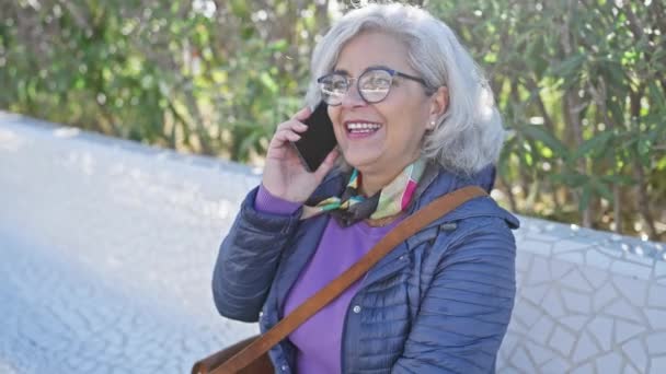 Mulher Madura Sorrindo Usando Smartphone Enquanto Verifica Smartwatch Ambiente Parque — Vídeo de Stock