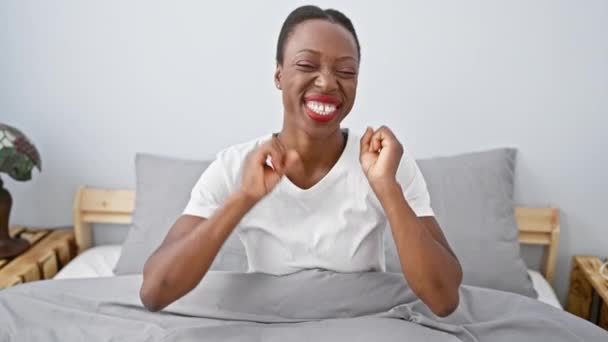 微笑着躺在卧室里的非洲裔美国女人 摆出一种滑稽而性感的爪子姿势 流露出一种咄咄逼人的表情来安慰自己的家 — 图库视频影像