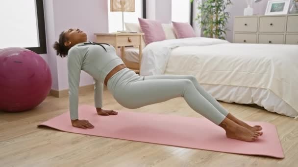 Jonge Vrouw Praktijken Brug Yoga Poseren Roze Mat Haar Slaapkamer — Stockvideo