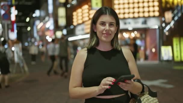 Mulher Hispânica Bonita Sorrindo Para Luzes Noturnas Urbanas Tokyo Enquanto — Vídeo de Stock