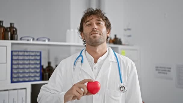 Tıbbi Laboratuvar Ortamında Kırmızı Kalp Mankeni Tutan Gülümseyen Bir Adam — Stok video