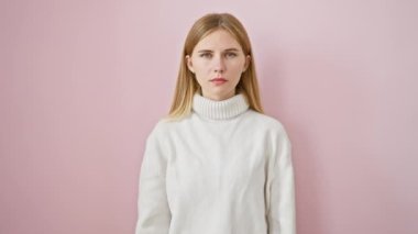 Kışın süveter giyen kızgın sarışın bebek olumsuz bir jest gösteriyor, tiksinti içinde başparmaklarını eğiyor, 