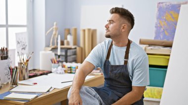 Stüdyodaki düşünceli İspanyol adam sanat malzemeleriyle bir sonraki eserini tasarlıyor..