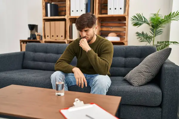 Arab man with beard working on depression at therapy office feeling unwell and coughing as symptom for cold or bronchitis. health care concept.