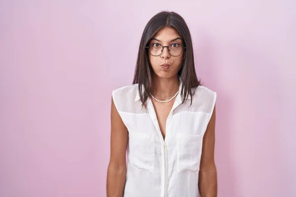Mujer Joven Morena Pie Sobre Fondo Rosa Con Gafas Hinchando — Foto de Stock