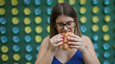 Gözlüklü güzel İspanyol kadın Tokyo 'nun canlı sokağında geleneksel Japon karpuzu atıştırmalığı yiyor.