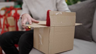 Genç İspanyol adam evde Noel hediyesi hazırlıyor.