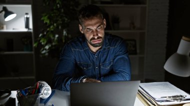 Genç İspanyol bir adam, ofiste uzun geceler çalışıyor; odaklanmış, ciddi ama rahat, bu sakallı profesyonel onun dizüstü bilgisayarında iş gezisi yapar.