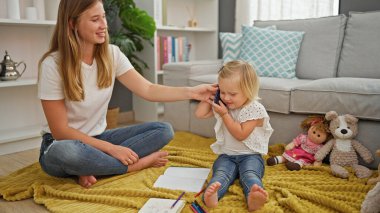 Kafkas anne ve kızının telefonda iç açıcı konuşması oturma odasında otururken, evde oyuncaklarla çevriliyken..