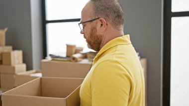 Yakışıklı, orta yaşlı beyaz bir adam, kendini işine adamış bir gönüllü, bağış paketini hayır merkezinde tutuyor, toplum hizmetinde özverili hizmet veriyor.