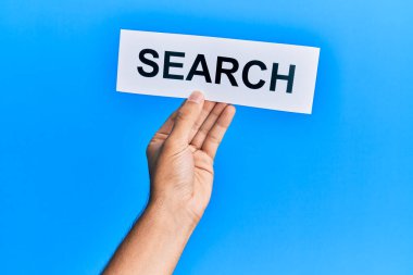 Hand of caucasian man holding paper with search word over isolated blue background