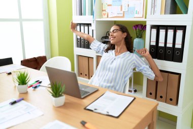 Young african american woman business worker tired stretching arms at office
