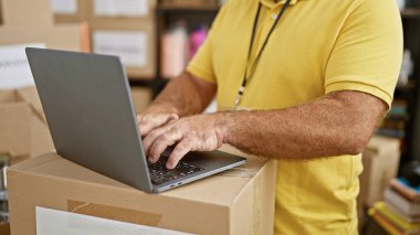 Yakışıklı, orta yaşlı, beyaz bir adam hayır kurumunda gönüllü olarak çalışıyor. Hizmet sırasında laptopunu kullanıyor. Sakallı, yetişkin bir erkeğin portresi, bütünlüğü ve fedakarlığı simgeliyor..