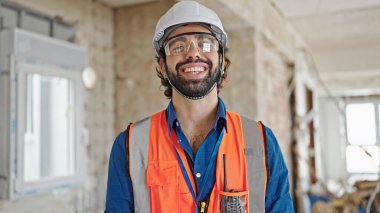 Şantiyede kendine gülen genç İspanyol mimar.