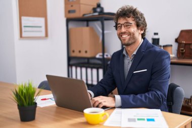 Young hispanic man business worker using laptop working at office