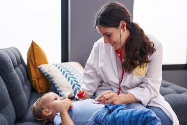 Anne ve oğul doktor evdeki çocuğu muayene ediyor.
