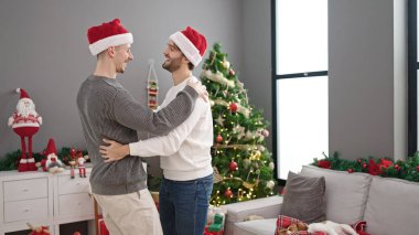 İki erkek Noel 'i kutluyor. Birbirlerine sarılıyorlar.