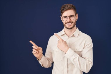 Mavi arka planda sakallı İspanyol adam gülümsüyor ve kameraya bakıyor.. 