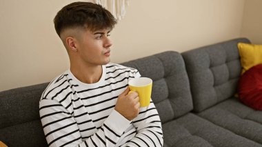 Çekici, genç İspanyol bir adam evde rahatlatıcı bir sabah geçiriyor. Ciddi ama rahat bir ifade. Oturma odasındaki kanepede rahatça oturup bir fincan zengin espresso kahvesinin tadını çıkarıyor..