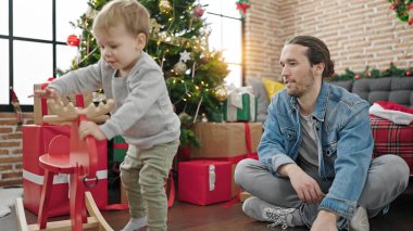 Baba oğul Noel 'i kutluyorlar. Ren geyikleriyle oynuyorlar.