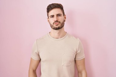 Pembe arka planda sakallı İspanyol bir adam canlı yayında öpüşürken kameraya bakıp sevimli ve seksi görünüyor. aşk ifadesi. 