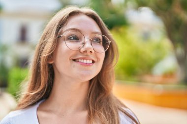 Young blonde woman smiling confident looking to the side at street