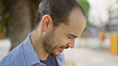 Sakallı, sakalsız, sıradan bir ortamda gülümseyen bir İspanyol..