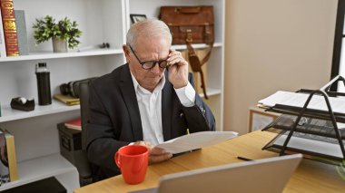 Üst düzey bir iş adamı ofiste belge okuyor.