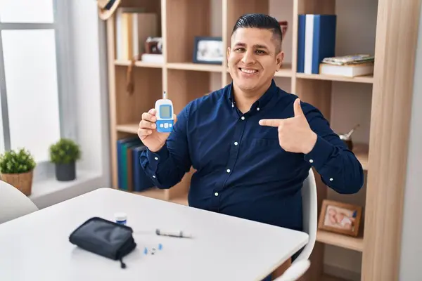 Hispanic Young Man Holding Glucometer Device Pointing Finger One Self — Stock Photo, Image