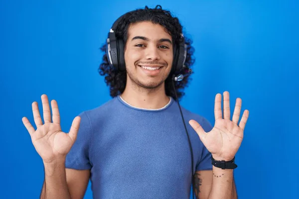 Hispanic Man Curly Hair Listening Music Using Headphones Showing Pointing — Stock Photo, Image