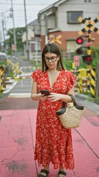 東京でメガネをかけた美しいヒスパニック女性 市街地のスマートフォンでデジタル接続 — ストック写真