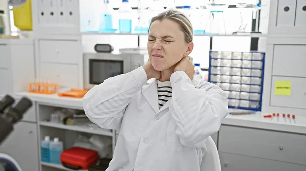 Young Caucasian Woman Lab Coat Winces Pain Touching Her Neck — Stock Photo, Image
