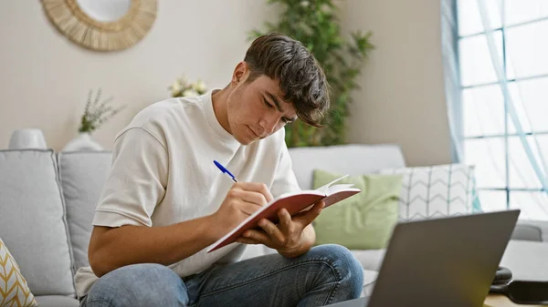 若いヒスパニック系のティーンエイジャーは ノートブックで勉強することに興奮し 自宅のソファに快適に座り 教育のための技術を採用しました — ストック写真