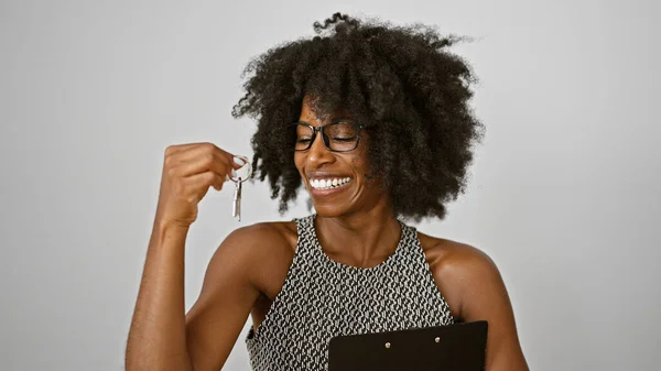 African american woman real state agent holding keys of new home smiling over isolated white background