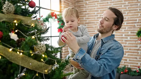 Father and son decorating christmas tree at home
