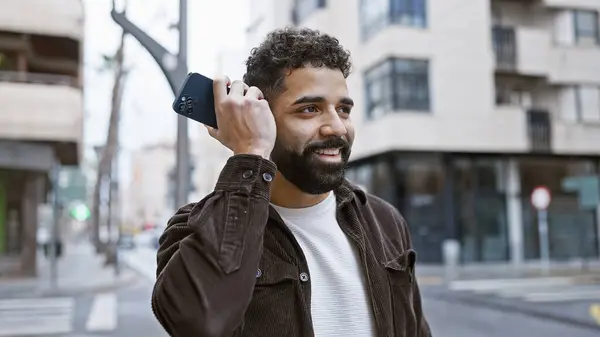 Uśmiechnięty Brodaty Hiszpan Odsłuchuje Wiadomość Głosową Telefonie Zewnątrz Miejskiej Ulicy — Zdjęcie stockowe