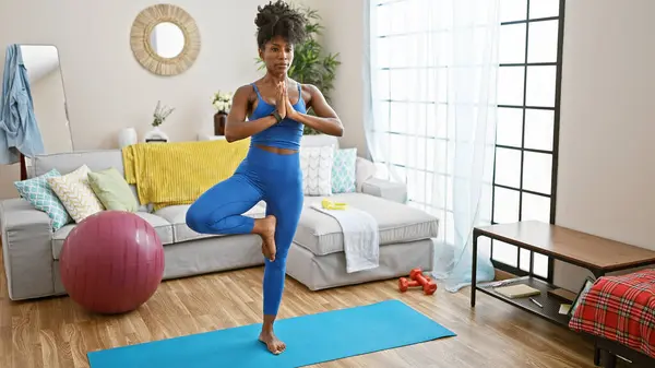 African american woman training yoga standing at home