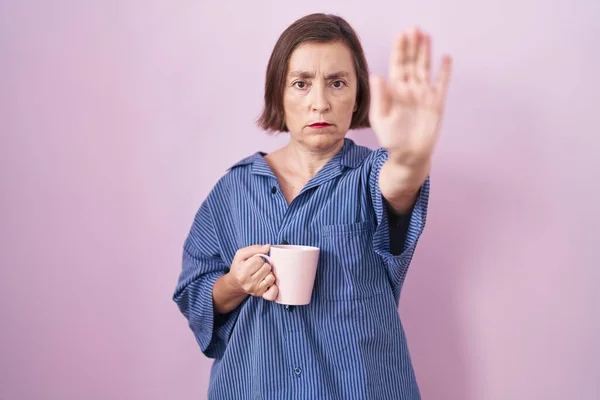 中年惊慌失措的女人喝了一杯咖啡 不停地用手掌唱歌 用消极而严肃的手势警告人 — 图库照片