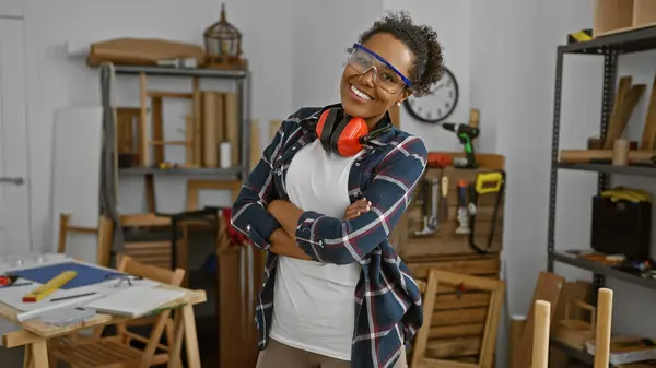 在木工车间里戴防护眼镜的自信女人 展示了行业的多样性 — 图库照片
