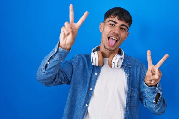 Young Hispanic Man Standing Blue Background Smiling Tongue Out Showing — Stock Photo, Image